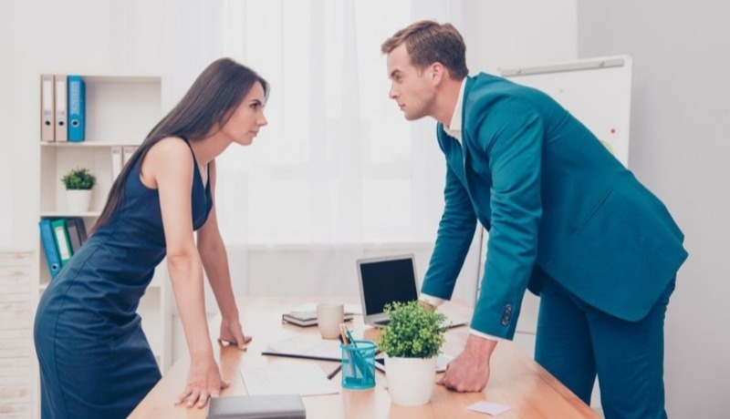 a woman and man staring at each other across table